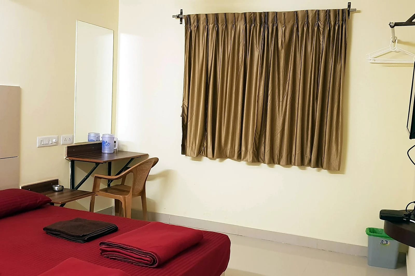 Nisarga Inn Grand — Deluxe room with desk and TV